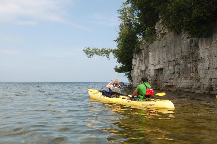 A couple on a tandem kayak on the death's door bluff tour