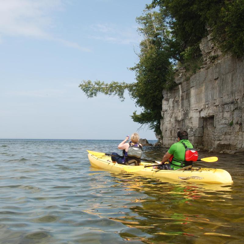 A couple on a tandem kayak on the death's door bluff tour
