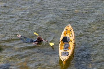 Man swimming to his kayak