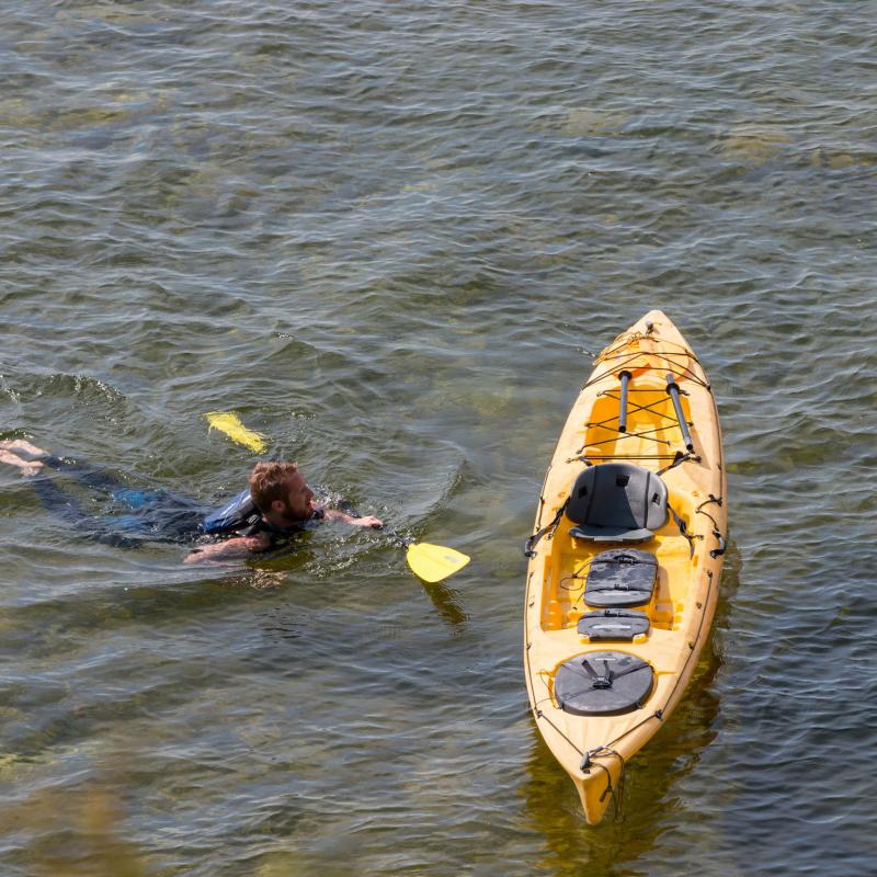 Man swimming to his kayak