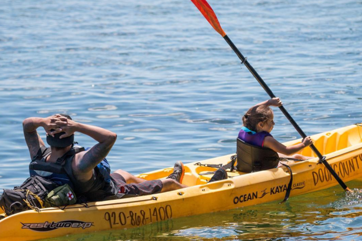 a group of people riding on the back of a boat in the water