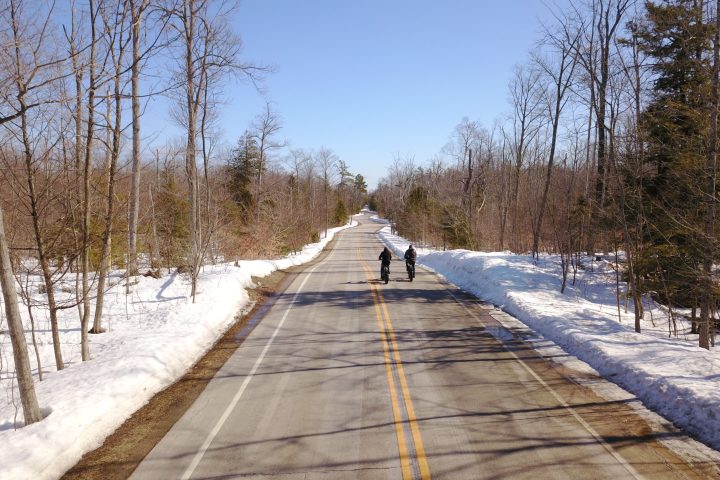 two bikers on a road during winter