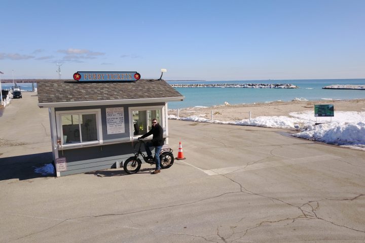 a biker parked in front of a ferry ticket stand
