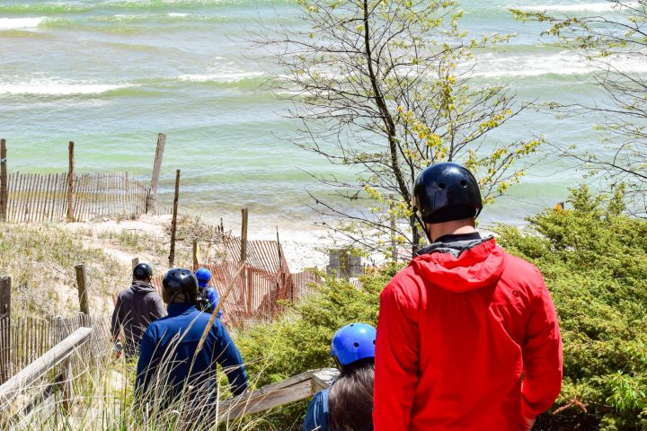 people walk down stairs towards the beach