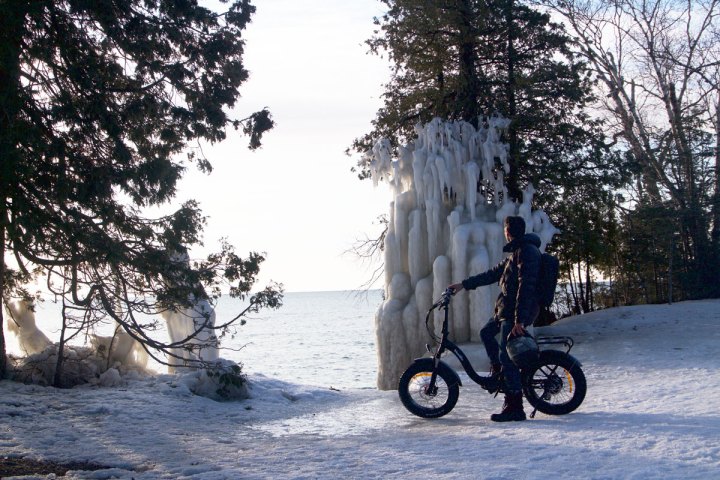 a man riding a motorcycle on the side of a snow covered slope