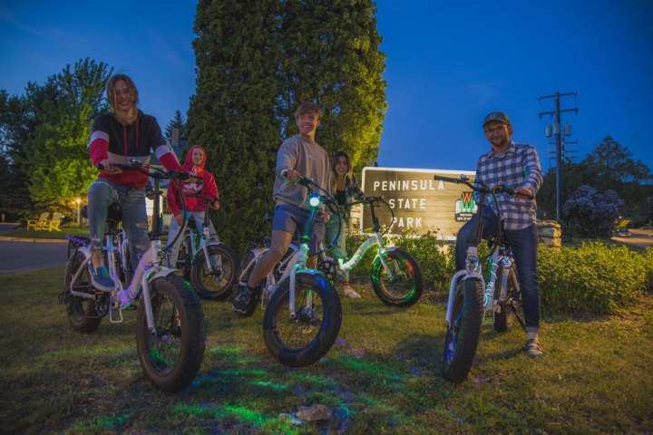 a group of people riding on the back of a bicycle