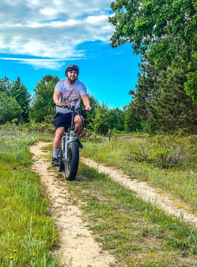 sunset-trail-peninsula-state-park-electric-bikes a man riding a motorcycle down a dirt road